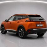 Оранжевый Peugeot 2008 2023 года, показанный сзади под углом