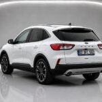White 2023 Ford Kuga shown in a studio from the rear three-quarter view