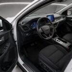 Interior of a white 2023 Ford Kuga with the driver’s door open