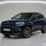 Темно-синий Jeep Compass 2026 года на студийном снимке спереди сбоку