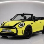 Sarı renkli 2023 model Mini Cooper Cabrio kabriyo, siyah şeritli ve açık tavanlı Antalya Belek'te park edilmiş