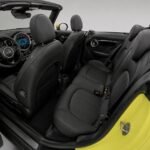 2023 model sarı Mini Cooper Cabrio'nun siyah deri koltukları ve direksiyon simidi iç mekanı